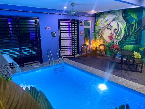 a pool in a room with a painting on the wall at Ilham Restu Homestay Private Pool MSLIM ONLY in Port Dickson