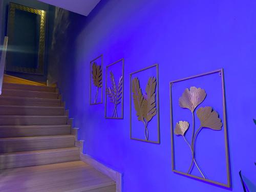 a purple wall with pictures of plants on a staircase at Ilham Restu Homestay Private Pool MSLIM ONLY in Port Dickson