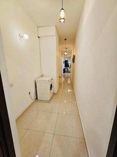 a hallway with a white wall and a tile floor at Secret Passage in Uswetakeiyawa