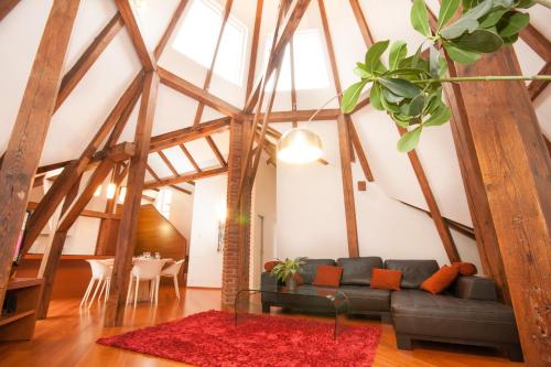 Una sala de estar con un sofá negro y una alfombra roja. en Luxury Loft, en Praga
