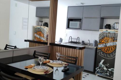 una sala da pranzo con un tavolo e una cucina di Apto Novo Próx Shopping Poços MG a Poços de Caldas