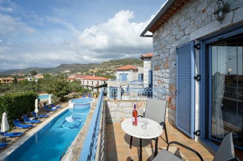 a balcony with a table and a swimming pool at Taletos Apartments in Stoupa