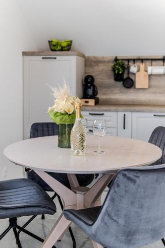 a table with a vase of flowers and a bottle of wine at Apartmani Indigo in Supetar