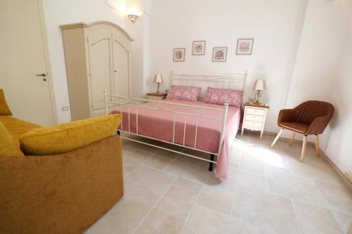 un dormitorio con una cama y una silla en La casetta di Iaia - Tricase, en Tricase