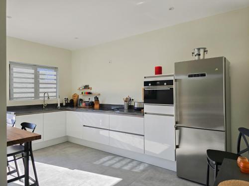 a kitchen with a stainless steel refrigerator and a table at La Cesarina in Willemstad