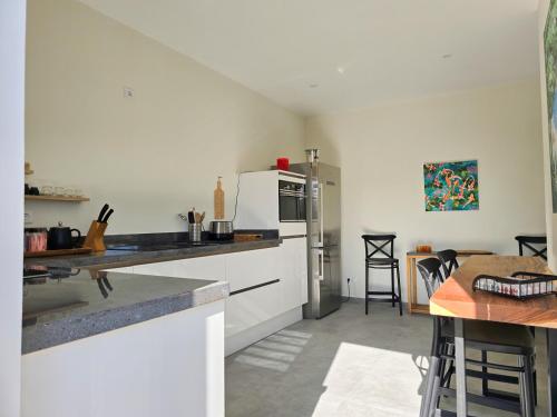 a kitchen with a white refrigerator and a table at La Cesarina in Willemstad