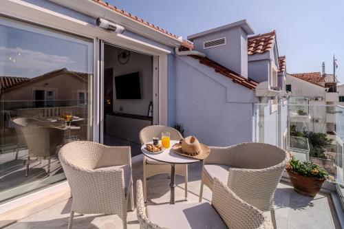 a patio with a table and chairs on a balcony at Apartmani Indigo in Supetar