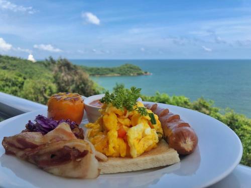 a plate of breakfast food with the ocean in the background at Agnus Unawatuna in Unawatuna