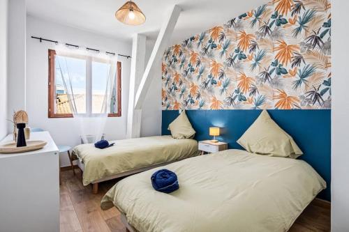 une chambre avec deux lits et un mur bleu dans l'établissement Charmant T3 - Cosy - Climatisation, à Béziers