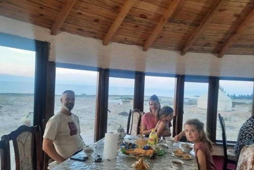 a group of people sitting at a table in a restaurant at Ethnocomplex Aikol in Tong