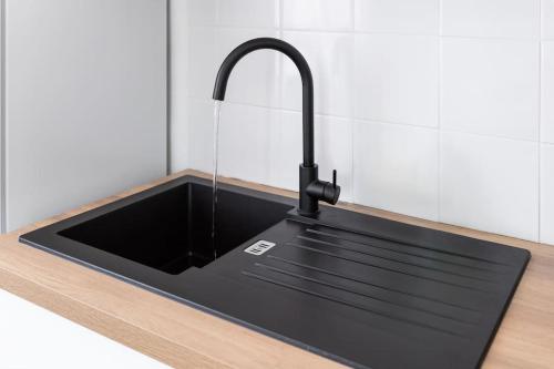 - un évier noir avec un robinet sur un comptoir dans l'établissement Charmant T3 - Cosy - Climatisation, à Béziers