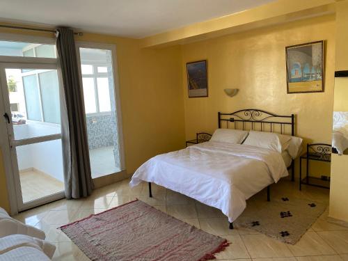 a bedroom with a bed and a large window at H&ocirc;tel Petite Su&egrave;de in Agadir