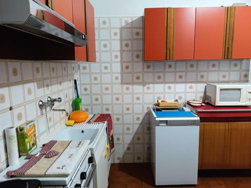 a kitchen with a stove and a microwave at Grazioso bilocale in Giusvalla