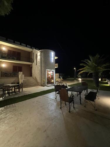 a patio with a table and chairs at night at Motel Zeta Lux in Mitrovići