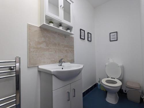 a white bathroom with a sink and a toilet at Room Near City Centre Private Bath Free Parking in Liverpool