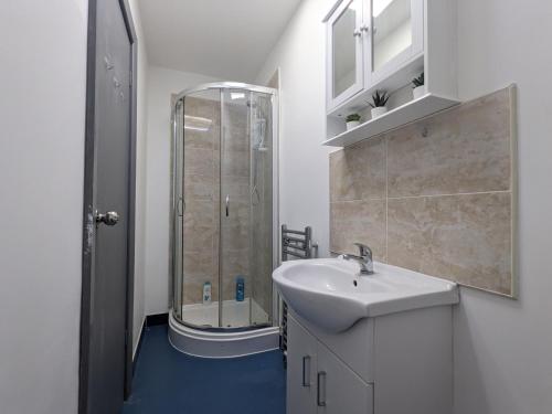 a white bathroom with a sink and a shower at Room Near City Centre Private Bath Free Parking in Liverpool