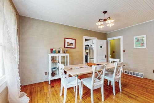 a dining room with a table and white chairs at Acorn House in Fletcher
