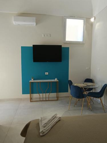 a living room with a tv and a table and chairs at Historic House in Ercolano