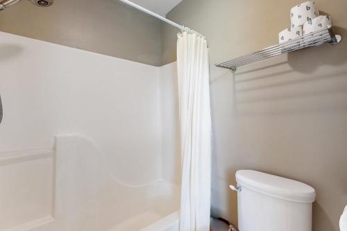 a bathroom with a toilet and a shower curtain at Acorn House in Fletcher