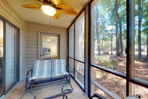 a rocking chair on a screened porch with windows at Pawleys Island #2 in Pawleys Island