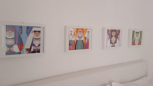 a group of pictures on a white wall in a museum at CIVICO 16A - Apartment - with private parking in Quartu SantʼElena