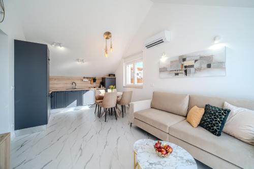 a living room with a couch and a kitchen at Apartmani Indigo in Supetar