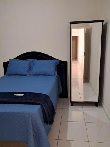een slaapkamer met een blauw bed en een spiegel bij Desativado in Petrolina