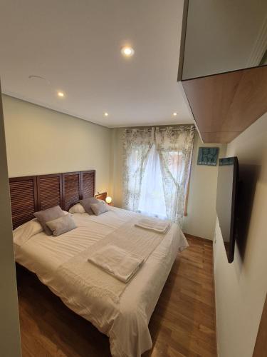 Un dormitorio con una cama grande y una ventana. en Playa de Mera, en Mera
