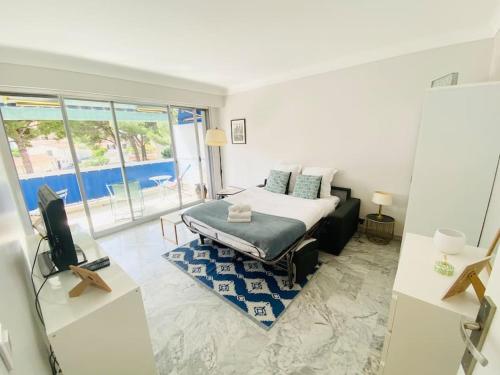 une chambre avec un lit et une télévision dans une pièce dans l'établissement Les nereides bord de mer calme lumineux parking, à Roquebrune-Cap-Martin