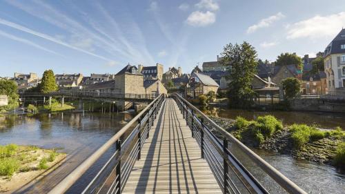 un pont sur une rivière dans une ville avec des bâtiments dans l'établissement VILLA Pablo, à Guingamp