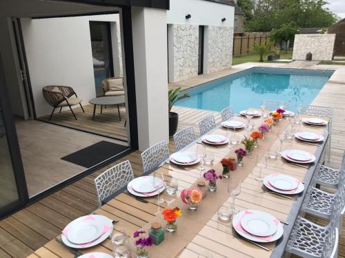- une table pour un repas à côté de la piscine dans l'établissement VILLA Pablo, à Guingamp