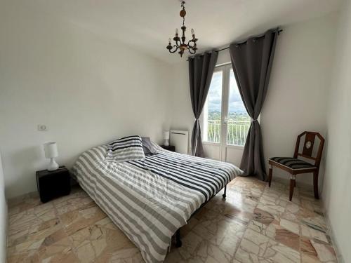 une chambre avec un lit, une fenêtre et une chaise dans l'établissement Ollioules, au coeur de la pinède, proche de la mer, à Ollioules