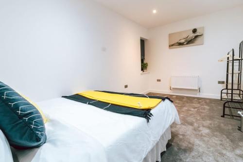 a bedroom with a large bed with a yellow pillow on it at Purley 2 Bed Flat in Purley