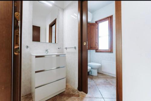 a bathroom with a sink and a toilet at Villetta Gio in Olìa Speciosa