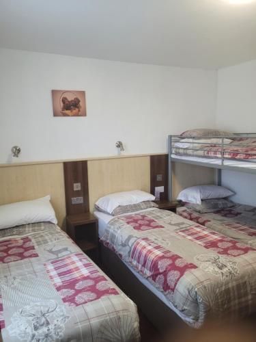 a room with two beds and two bunk beds at The Gatwick White House Hotel in Horley