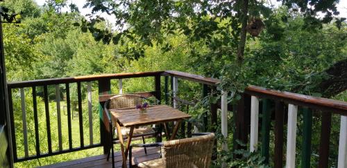 a wooden table and two chairs on a deck at Les Robinsonades in Couladère