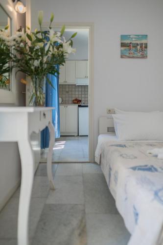 a bedroom with two beds and a table with a vase of flowers at Agia Anna Living in Agia Anna Naxos