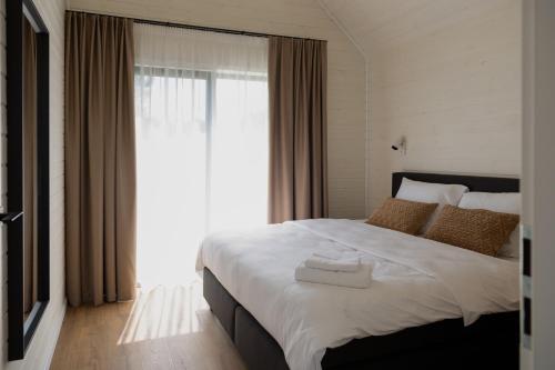 a bedroom with a large bed with a large window at Resort 23 in Želviai