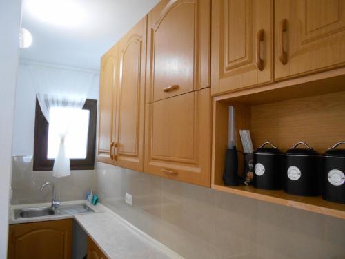 a kitchen with wooden cabinets and a sink at Pepi Cozy in Alexandroupoli