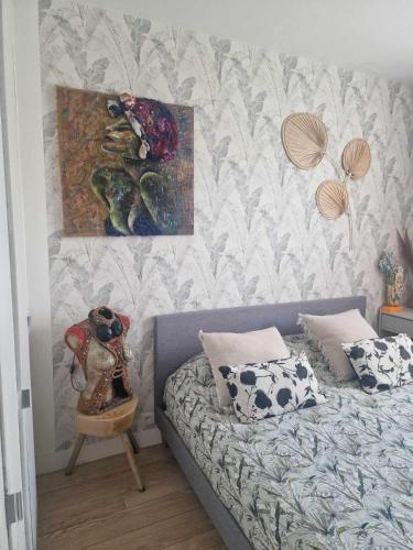 une chambre avec un lit et un tableau au mur dans l'établissement Le jasmin, à Aulnay-sous-Bois