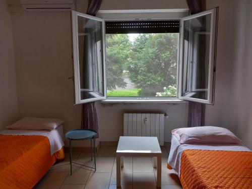 een kamer met twee bedden en een raam bij Apartamento vicino Policlinico San Donato in San Donato Milanese