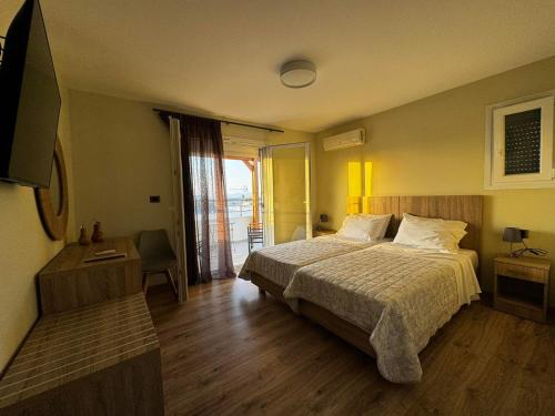 a hotel room with a bed and a television at Andreas Studios in Mastichari