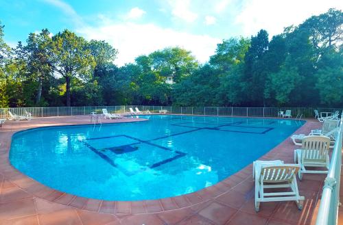 une grande piscine avec deux chaises et un terrain de volley-ball dans l'établissement Saint Tropez centre en style Piscine AC mer 100m, à Saint-Tropez