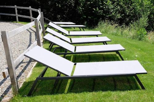 a row of white benches sitting in the grass at Trautesheim Ferienwohnungen in Wangen im Allgäu