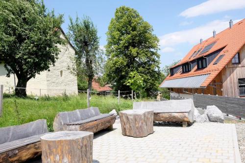 a patio with logs and couches and a house at Trautesheim Ferienwohnungen in Wangen im Allgäu
