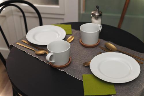a table with plates and cups and spoons on it at Maison Saporiti in Vigevano