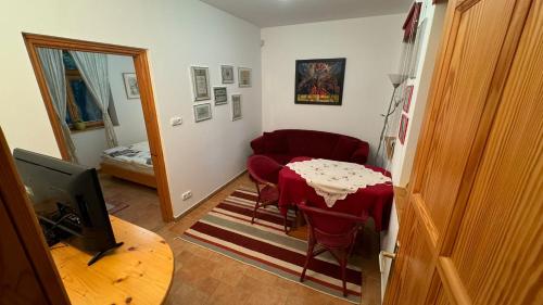 a living room with a table and a red chair at Reichelhausen Vendégház in Kiskunhalas
