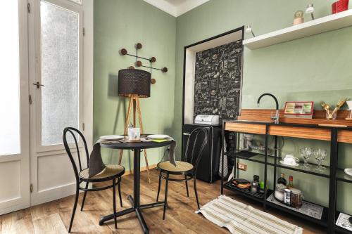 a table and chairs in a room with green walls at Maison Saporiti in Vigevano