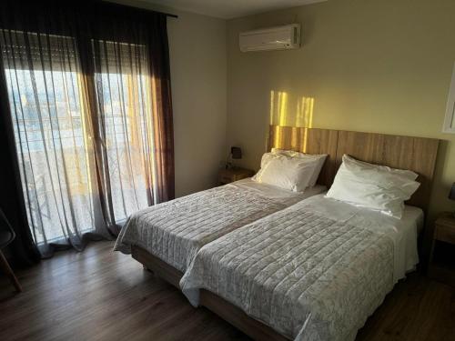 a bedroom with a large bed and two windows at Andreas Studios in Mastichari
