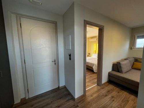 a room with a door and a couch and a bedroom at Andreas Studios in Mastichari